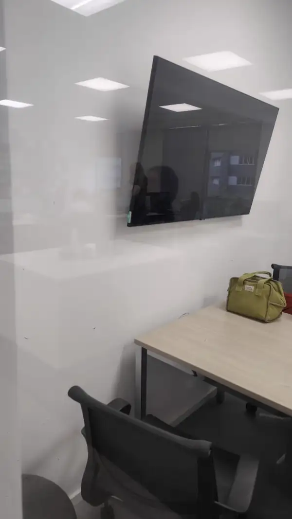 Televisão fixada na parede do escritório